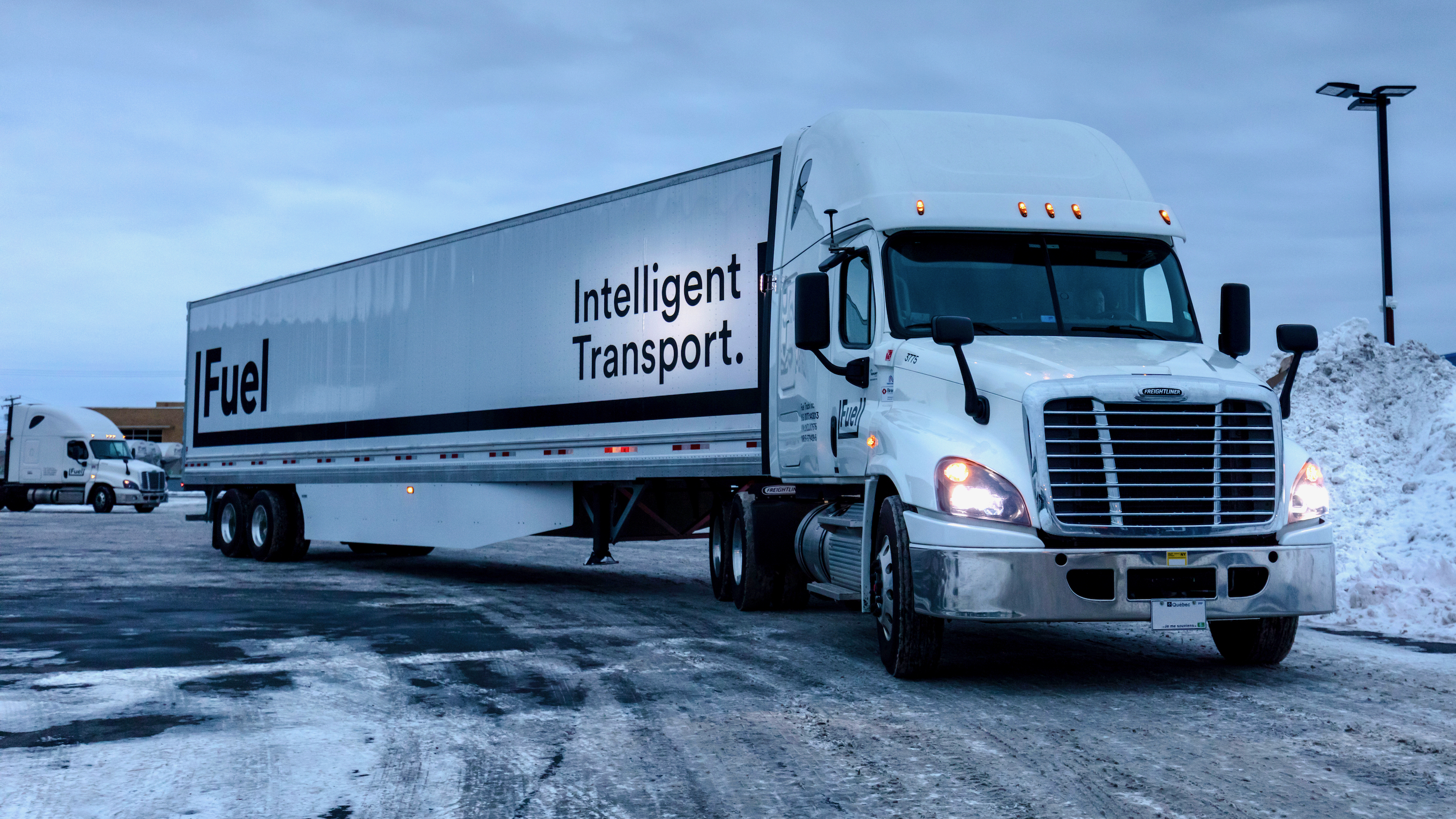 A tractor-trailer of Canadian trucking Fuel Transport is driven on a snowy day.