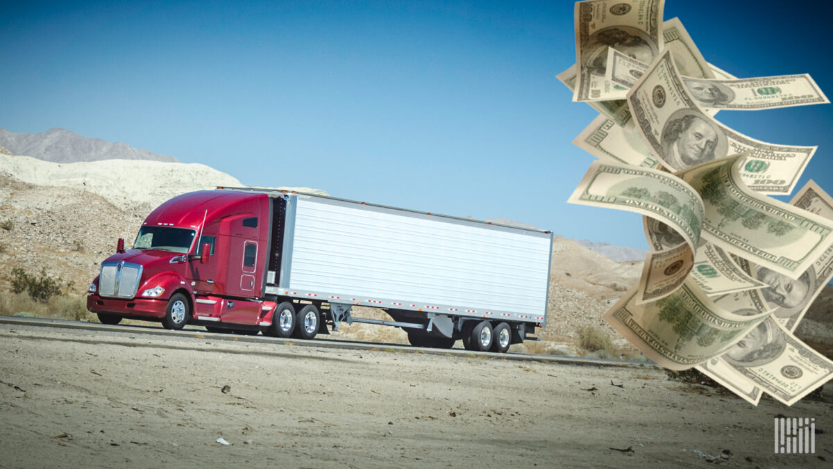 A red an white tractor trailer and $100 bills to illustrate the potential downturn facing the trucking industry..