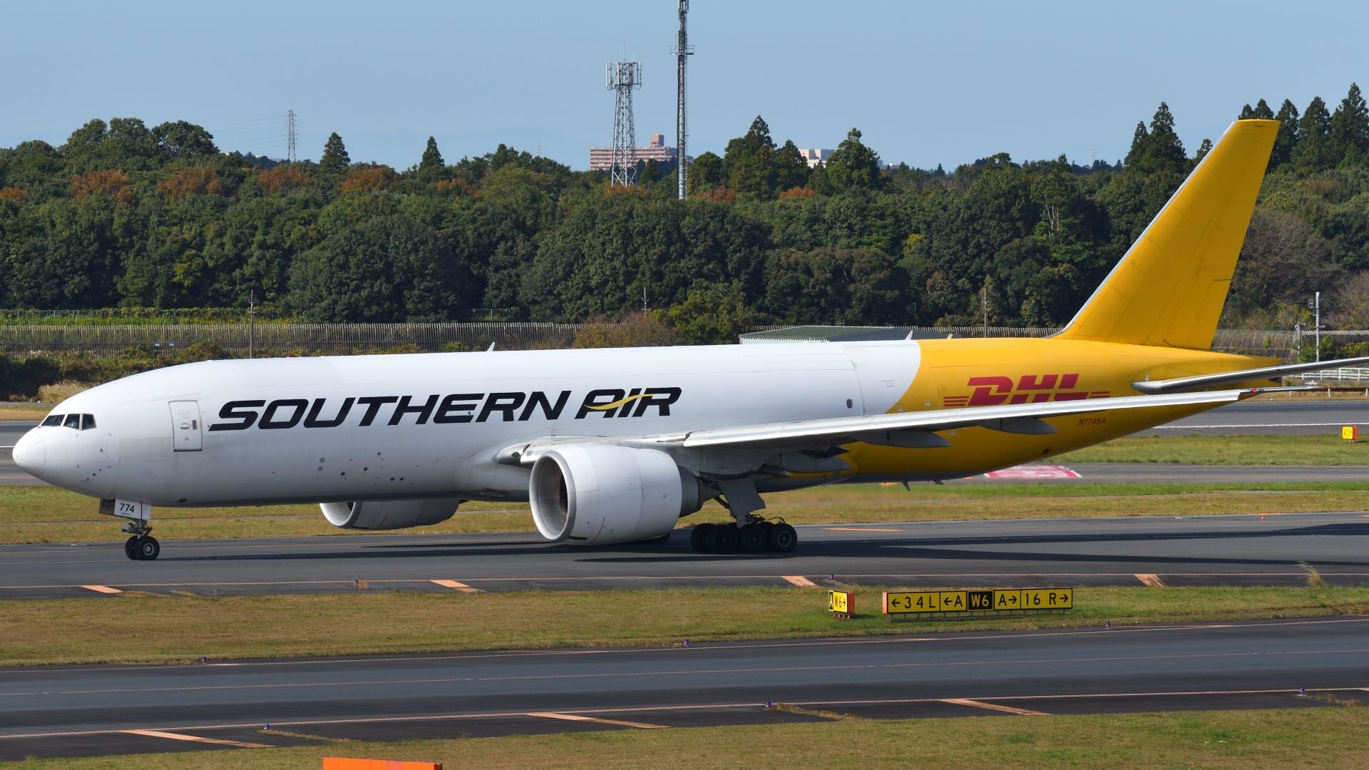 A Southern Air cargo jet, white on front end, and mustard color on rear.