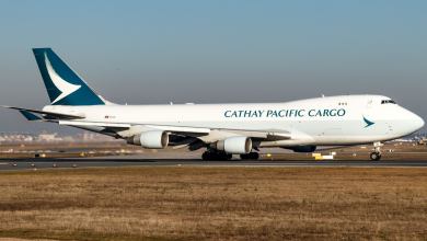 A white jumbo jet with teal colored tail and Cathay Pacific Cargo lettering.