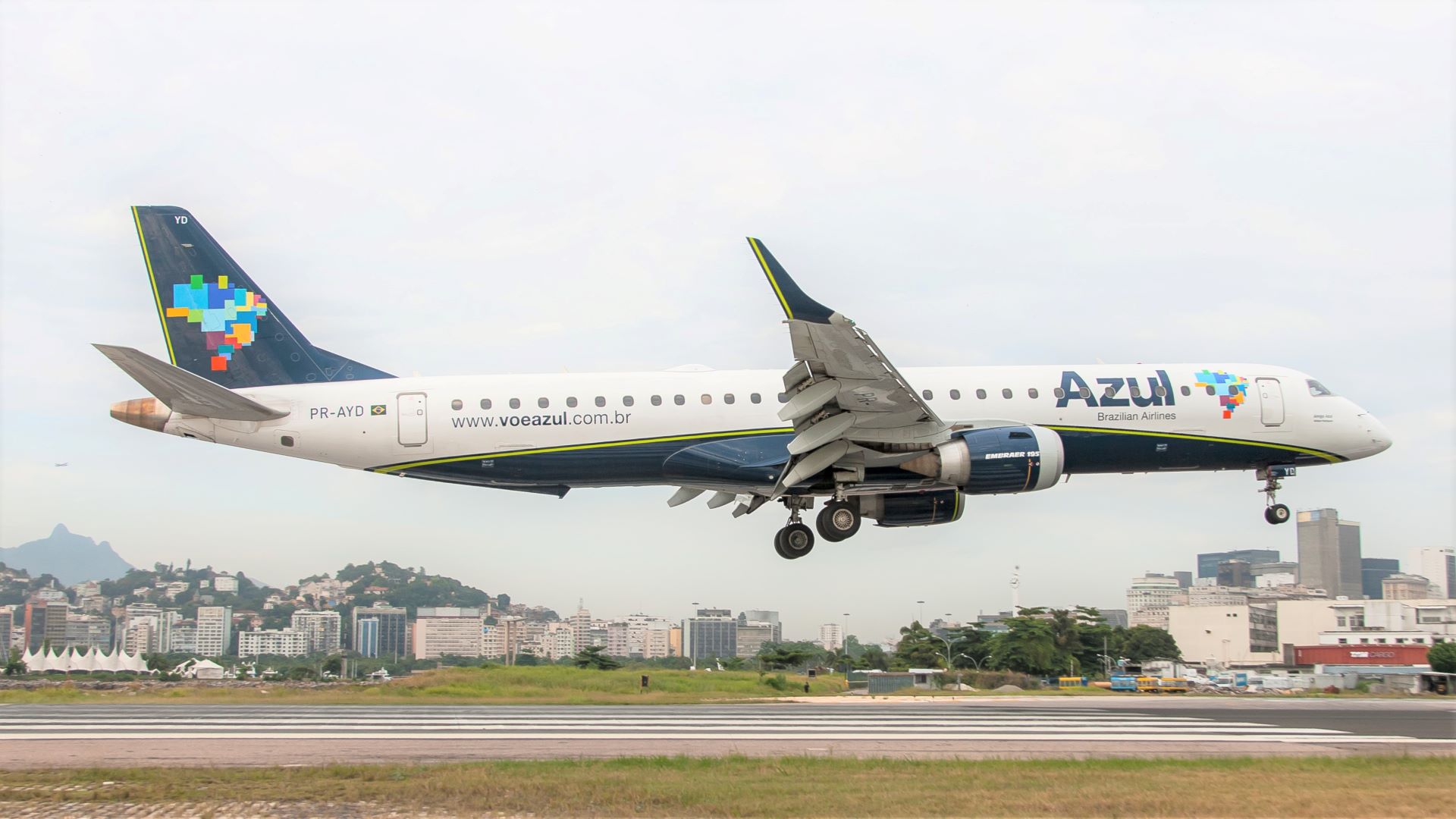 A white Azul regional jet with blue tail landing.