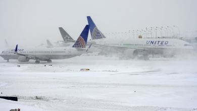 Planes on the tarmac in snowy weather.