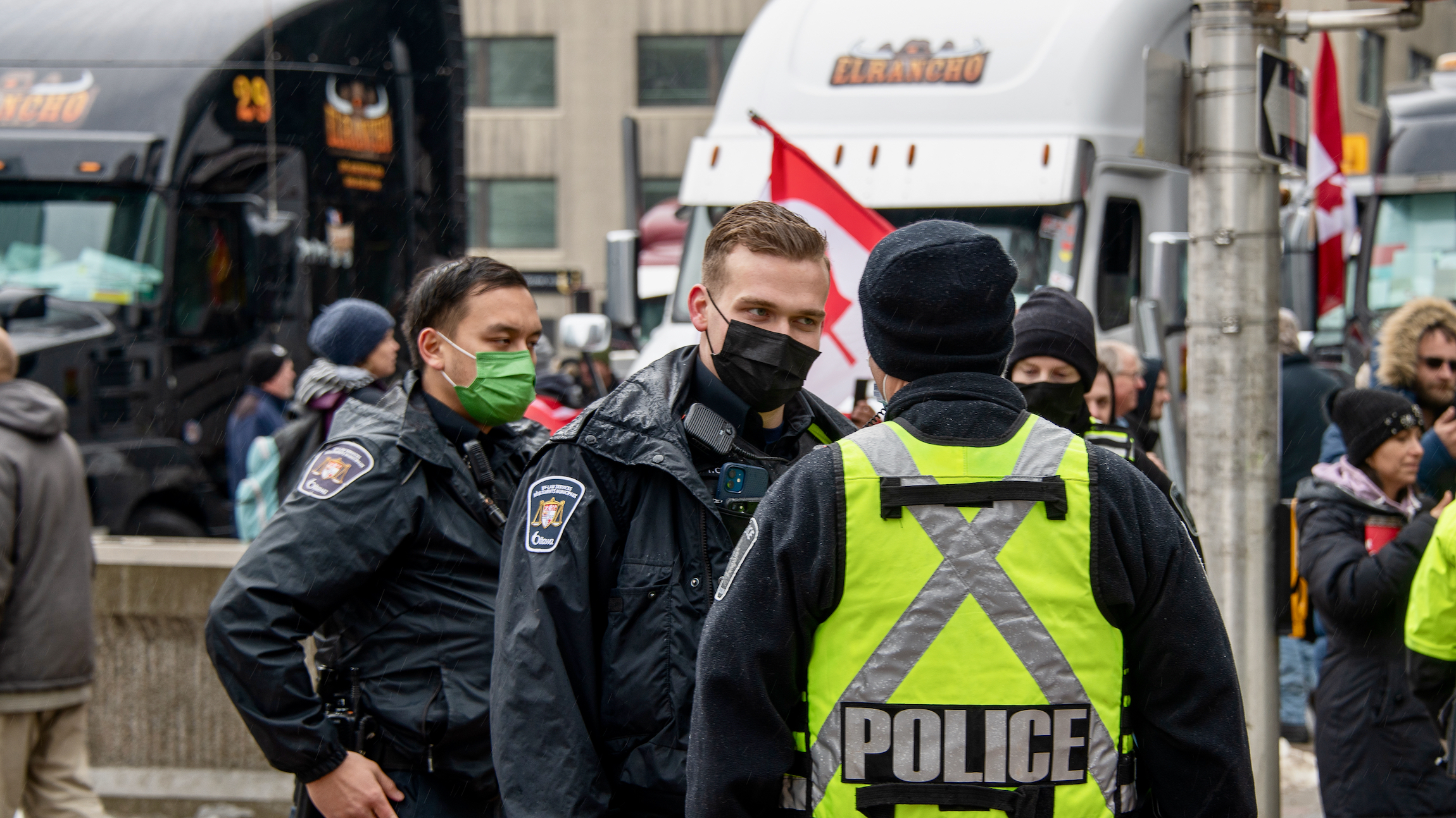 Police officers are seen in front of trucks at a protest in Ottawa