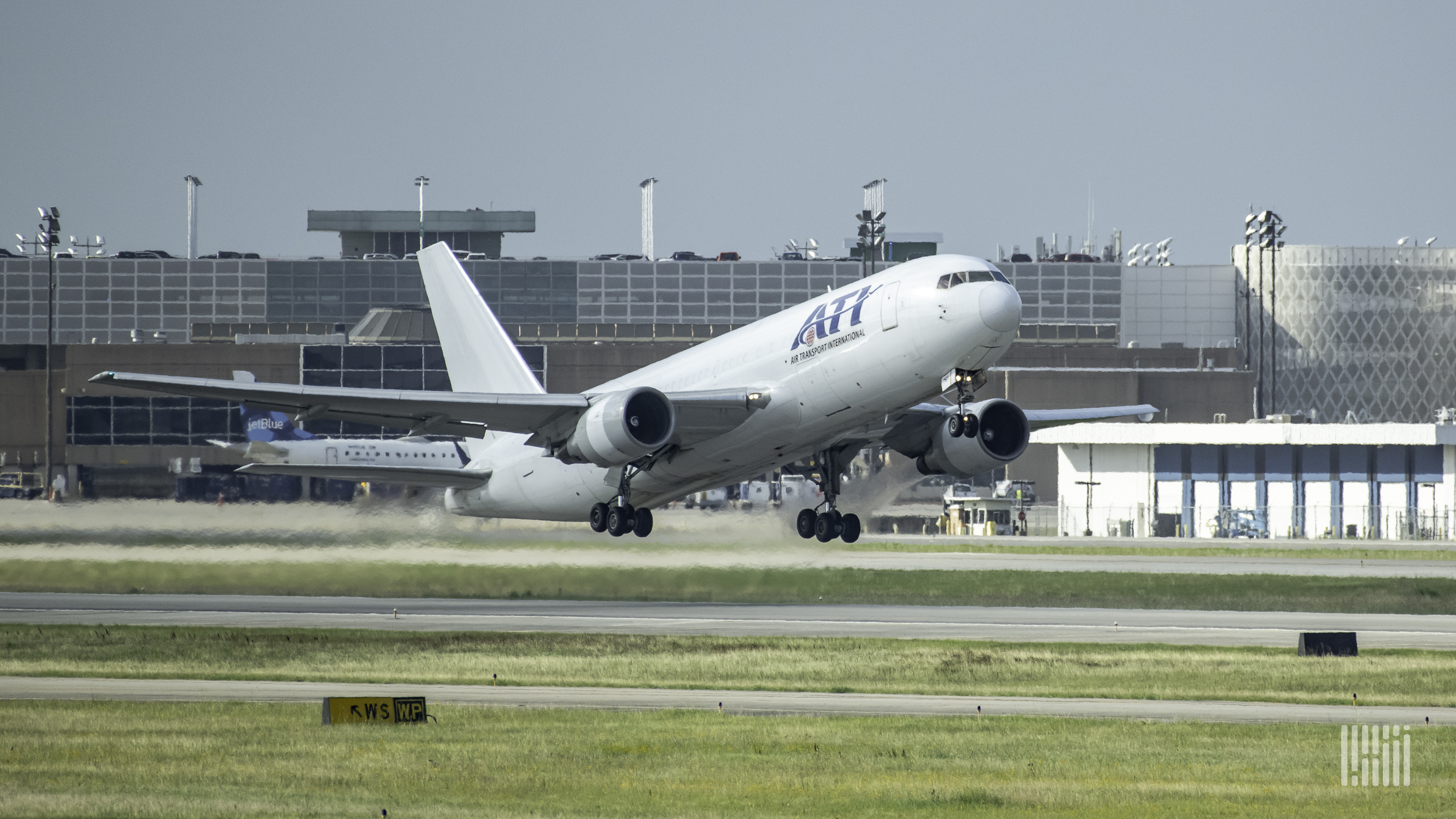 A white Air Transport International plane touches down on runway.