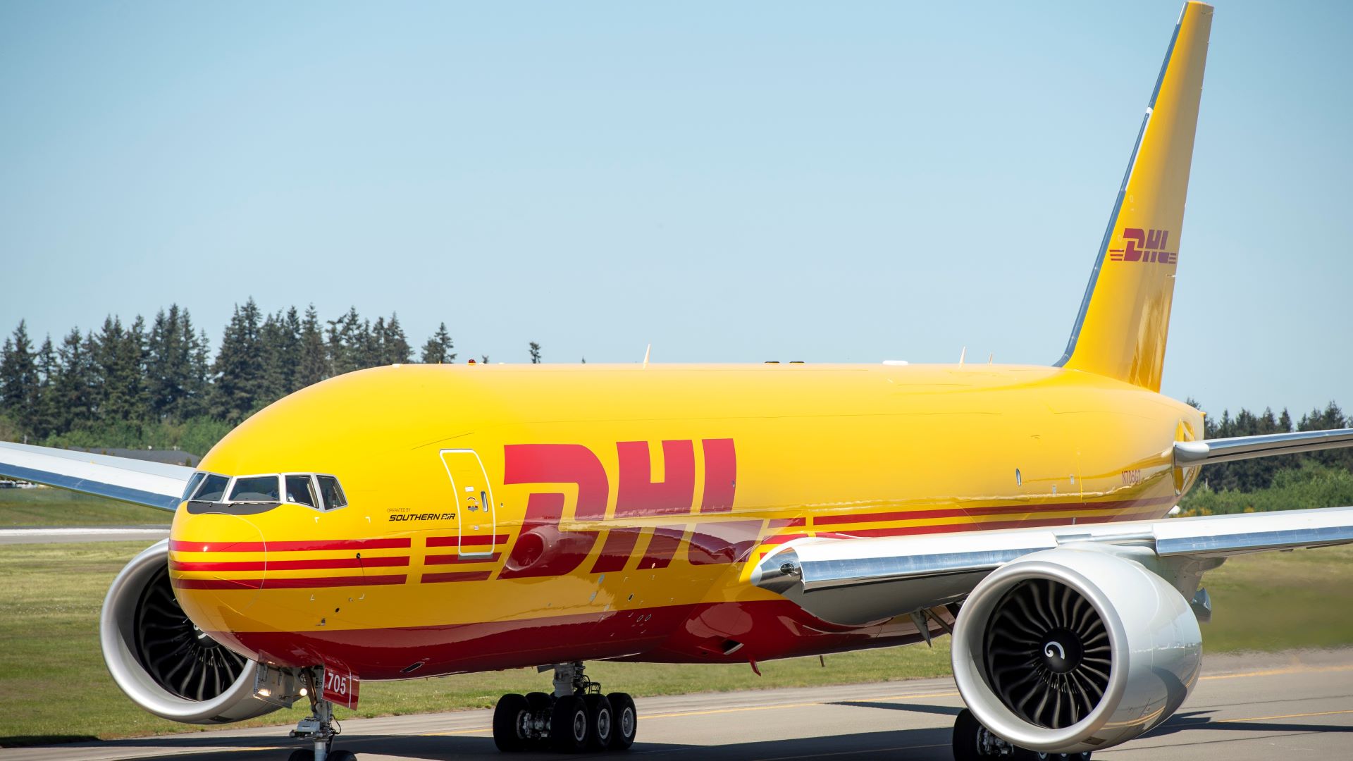 A mustard-colored DHL jet on the ground.