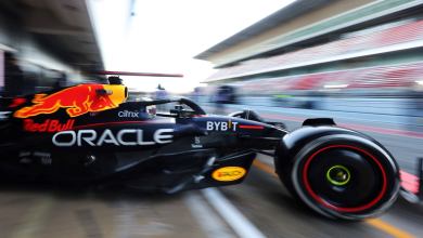 A blurred side close up of the Red Bull Formula One racing car exiting the garage.