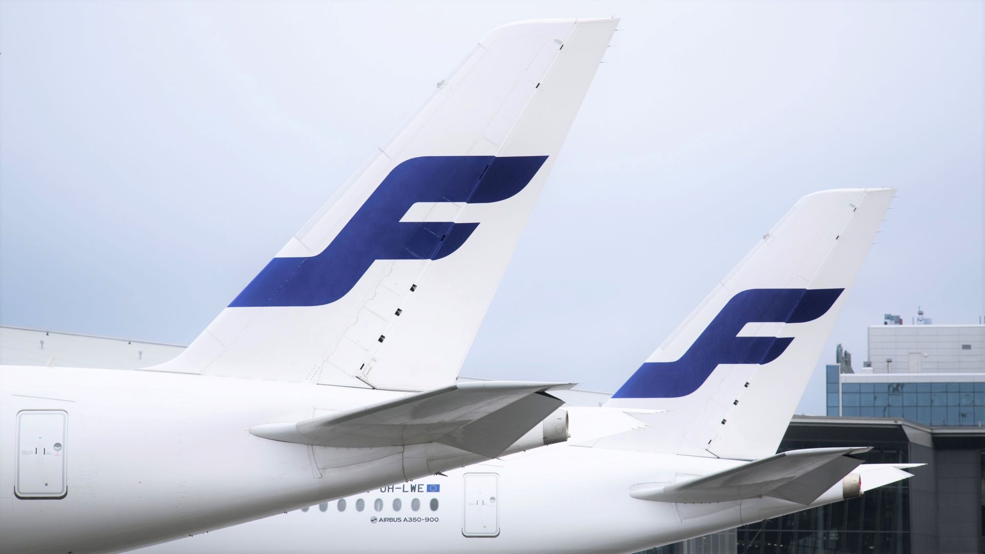Tail shot of two Finnair jets with an "F" on the tail.
