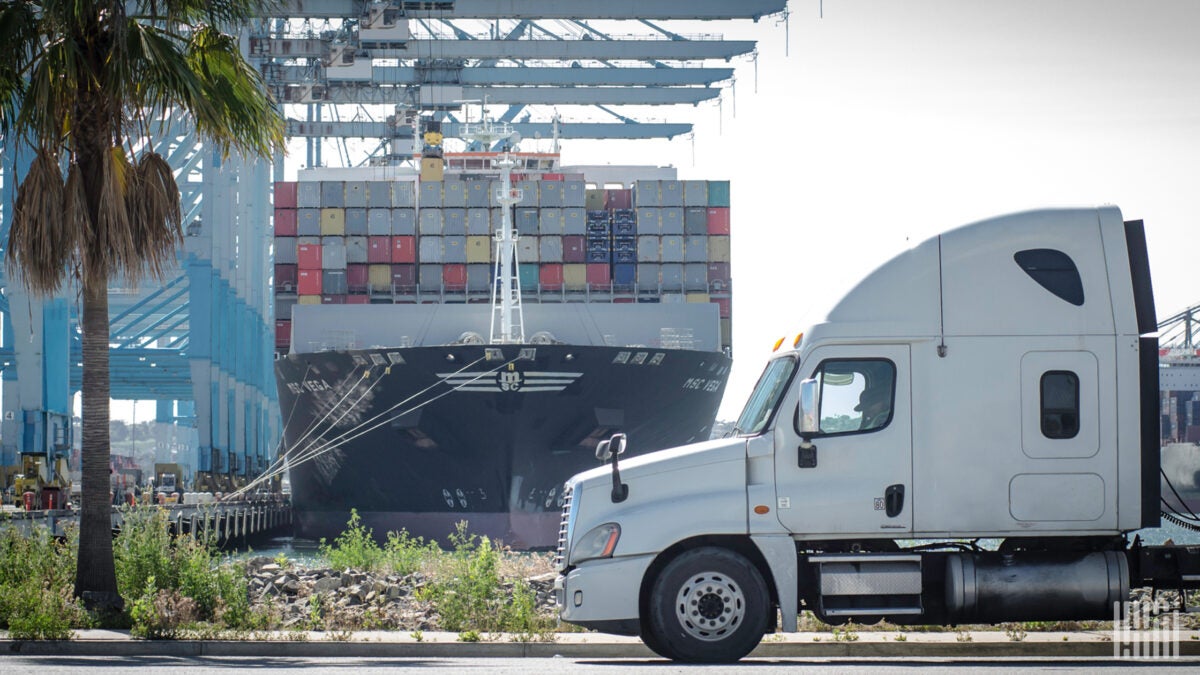 A white drayage truck picking up cargo at the Port of Los Angeles. 