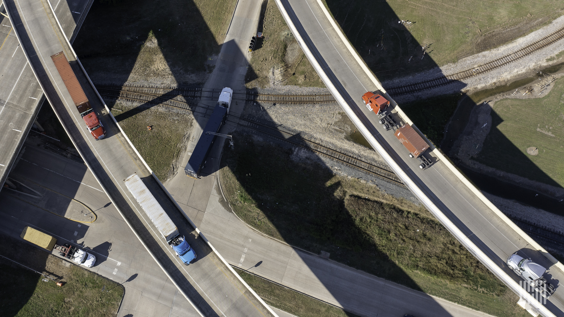 An aerial view of semi-trucks passing on major roads are moving goods.