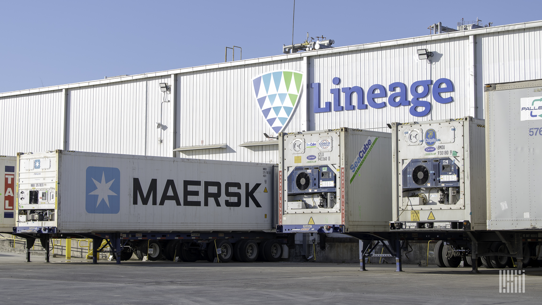 Trailers are docked at a warehouse facility with the name Lineage written on it.