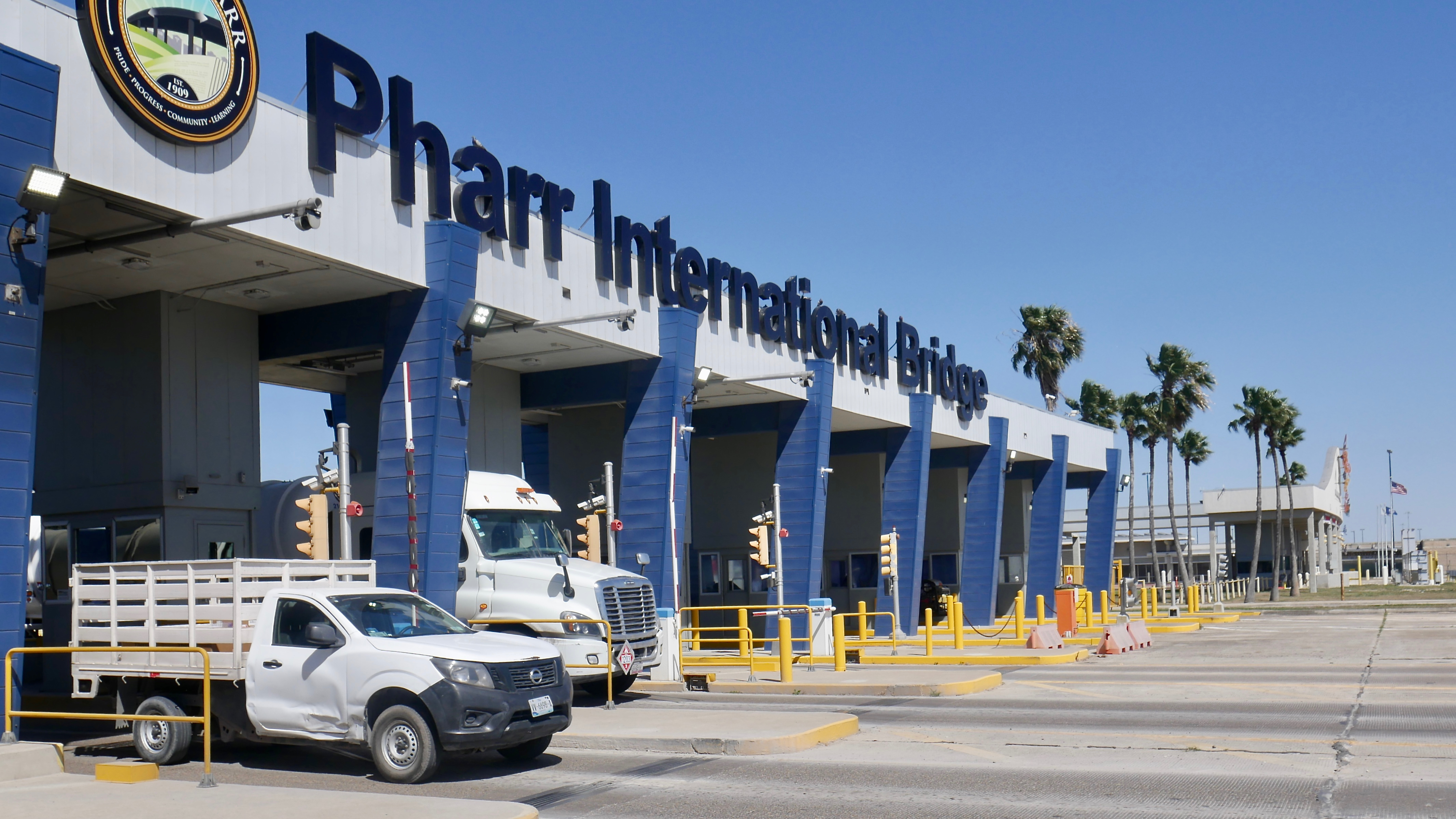 A view of trucks moving through a border checkpoint that reads Pharr International Bridge