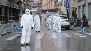 Medical staff in white hazmat suits on the streets of Shanghai. A mass quarantine has made it very difficult for trucks to get through the city.
