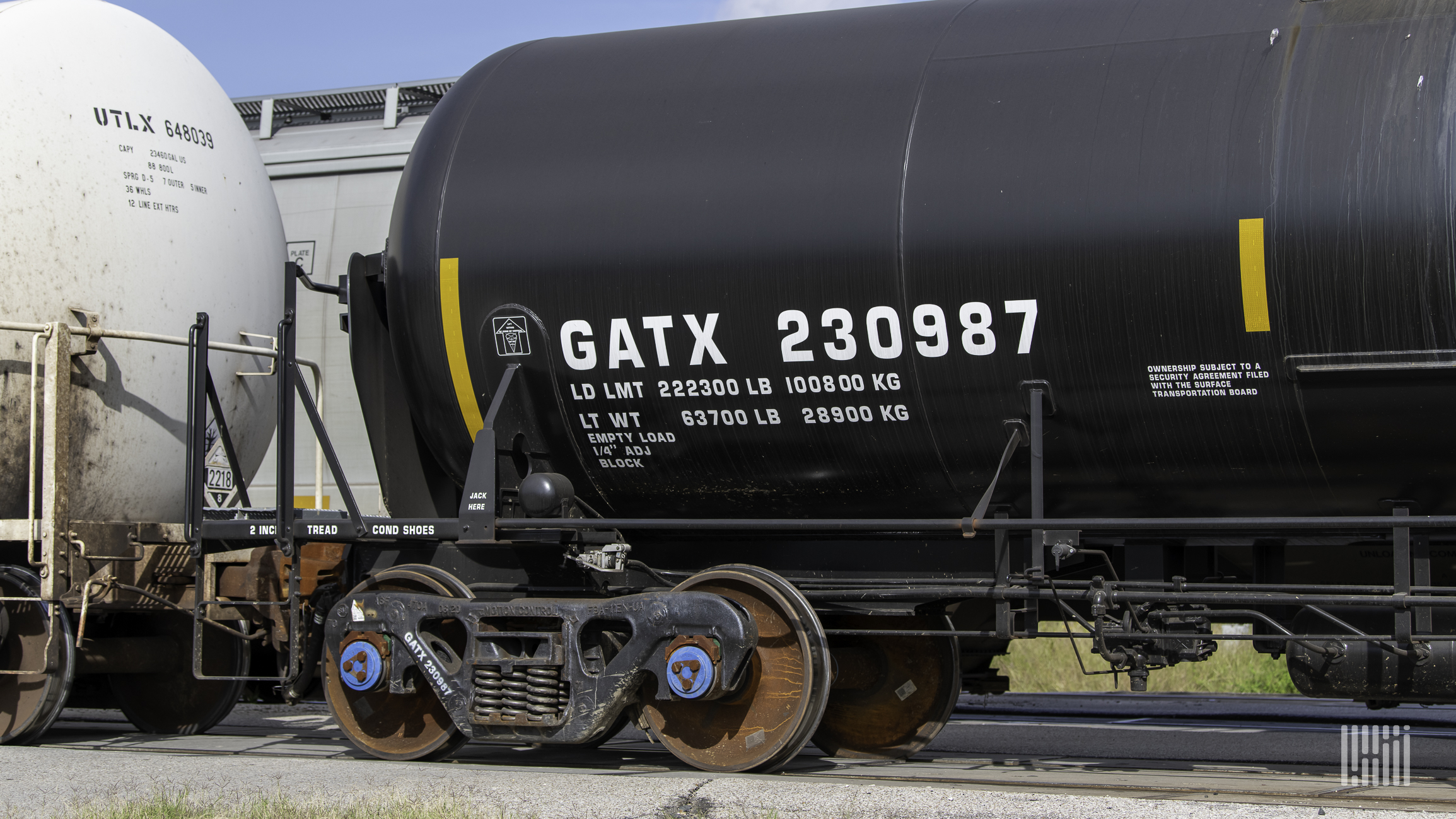 A photograph of a GATX tank car next to other tank cars in a rail yard,