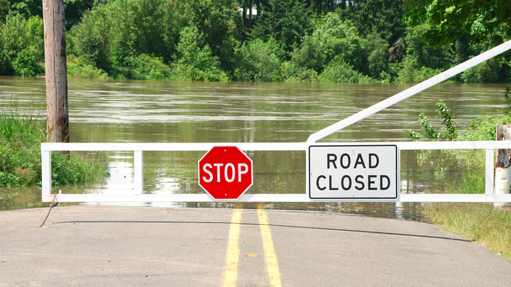 "Road Closed" sign in front of flooded street.