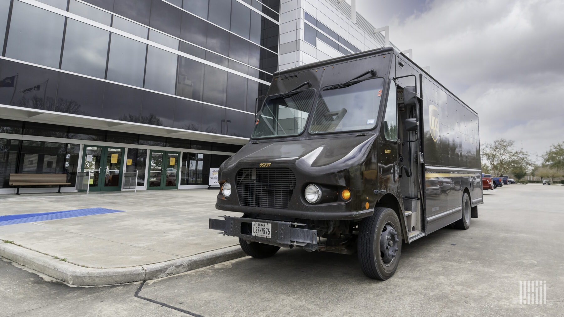 A brown UPS delivery van parked outside a building