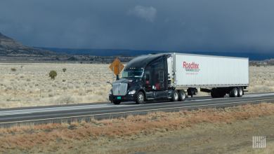 Black tractor and white Roadtex trailer on highway