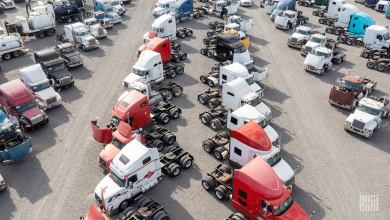 Aerial view of multi-colored used trucks in an auction parking lot.