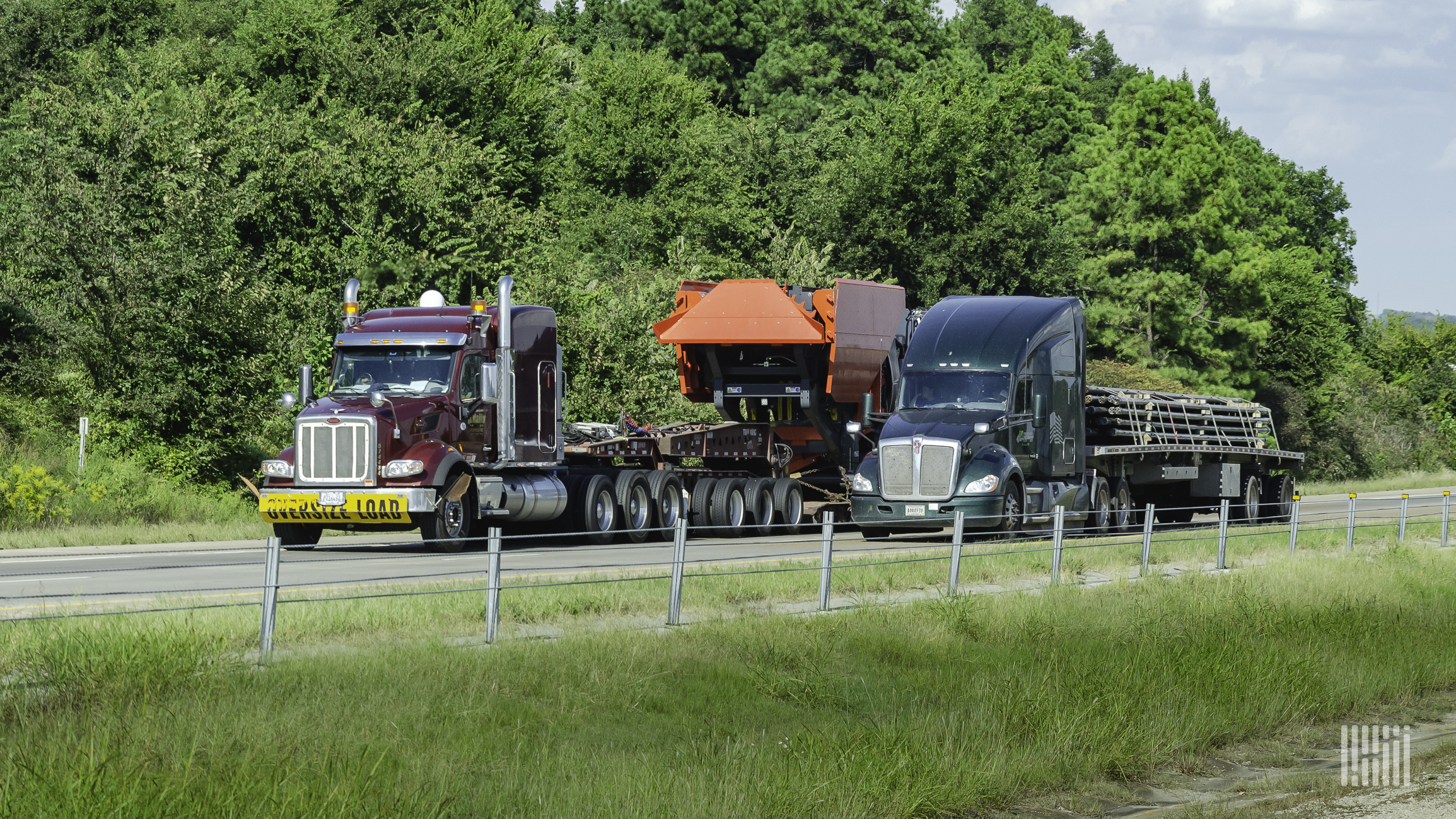 A truck hauling an open deck trailer