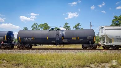 Two tank cars and a hopper car travel on the railroad.