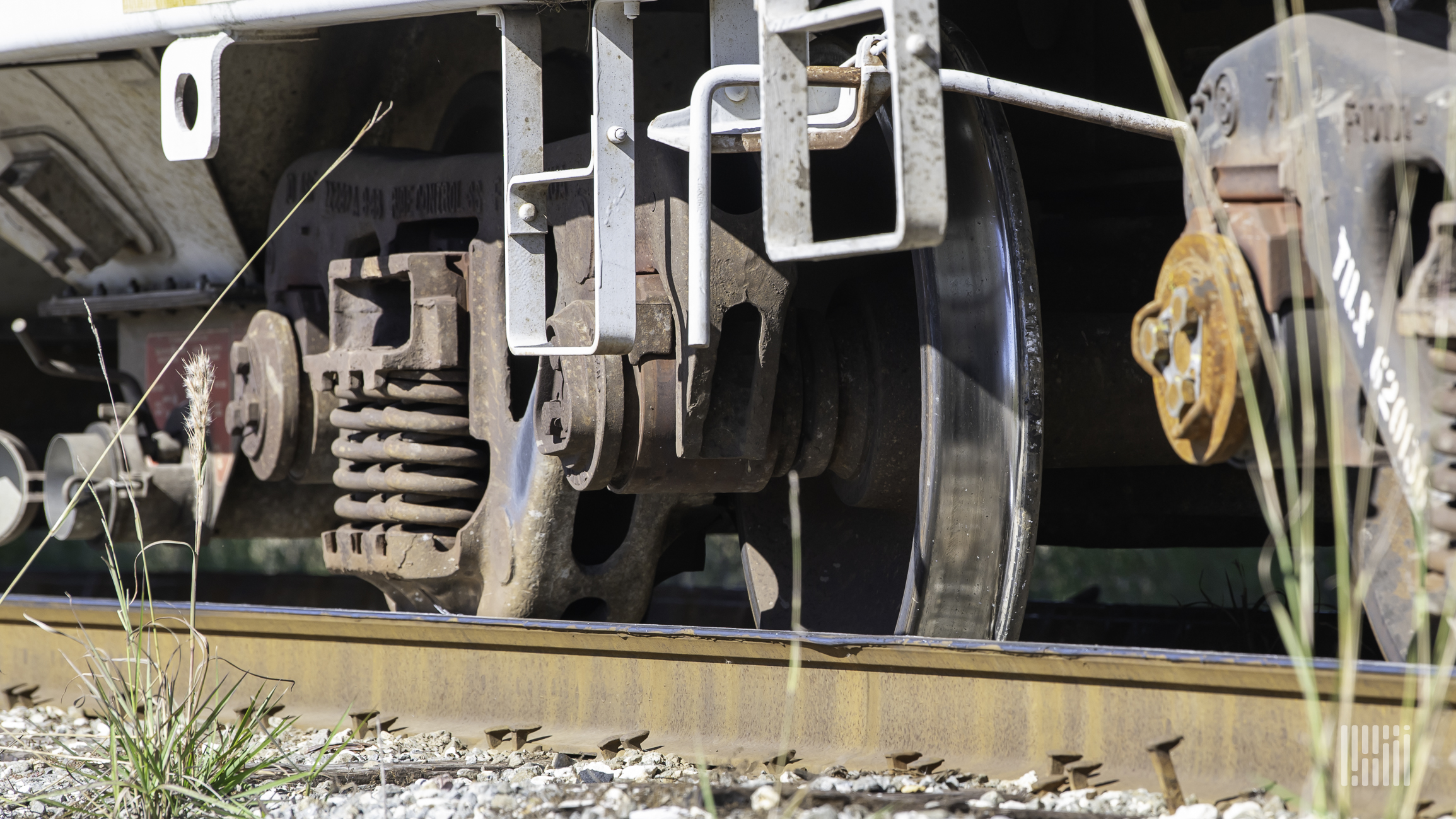 A close-up photo of railcar wheels on a rail track.