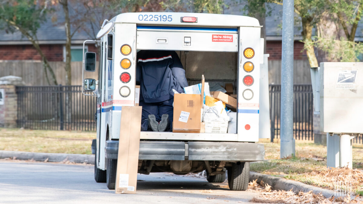 Postal Service truck unloading packages on the street