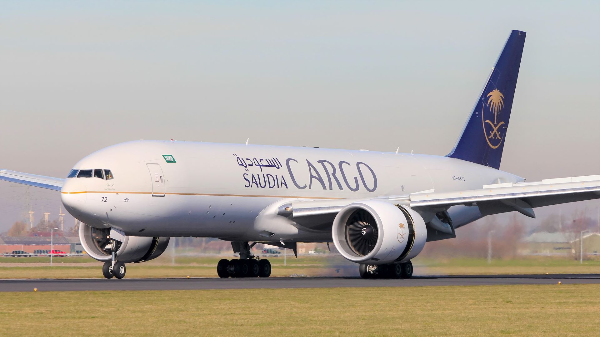 A large white jet with dark green tail and logo Saudia Cargo on the tarmac.