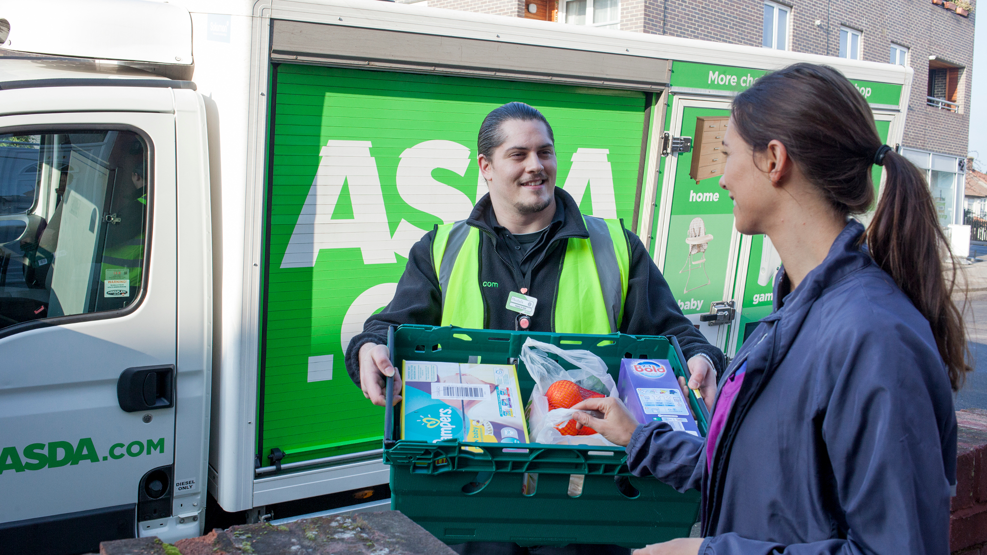 Delivery man hands grocery items to woman