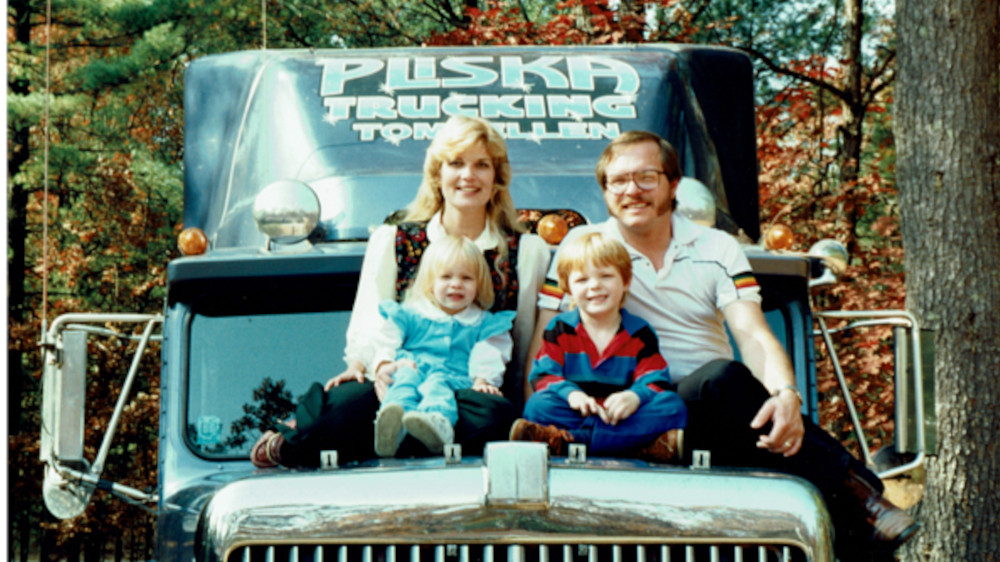 Ellen Voie and family sit on the hood of a truck.