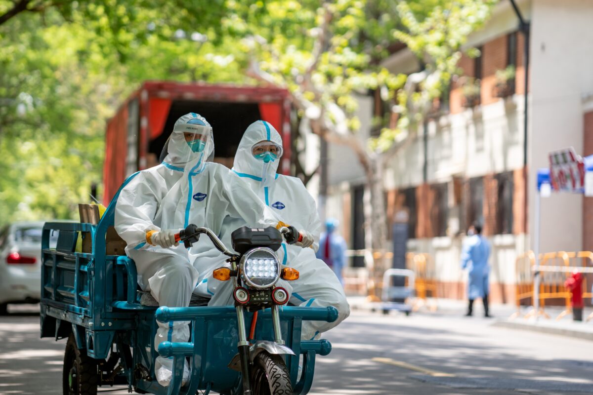 Two people in hazmat-suits drive