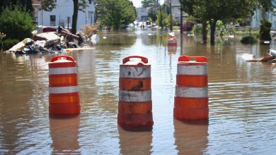 Orange and white barricades on a flooded road.