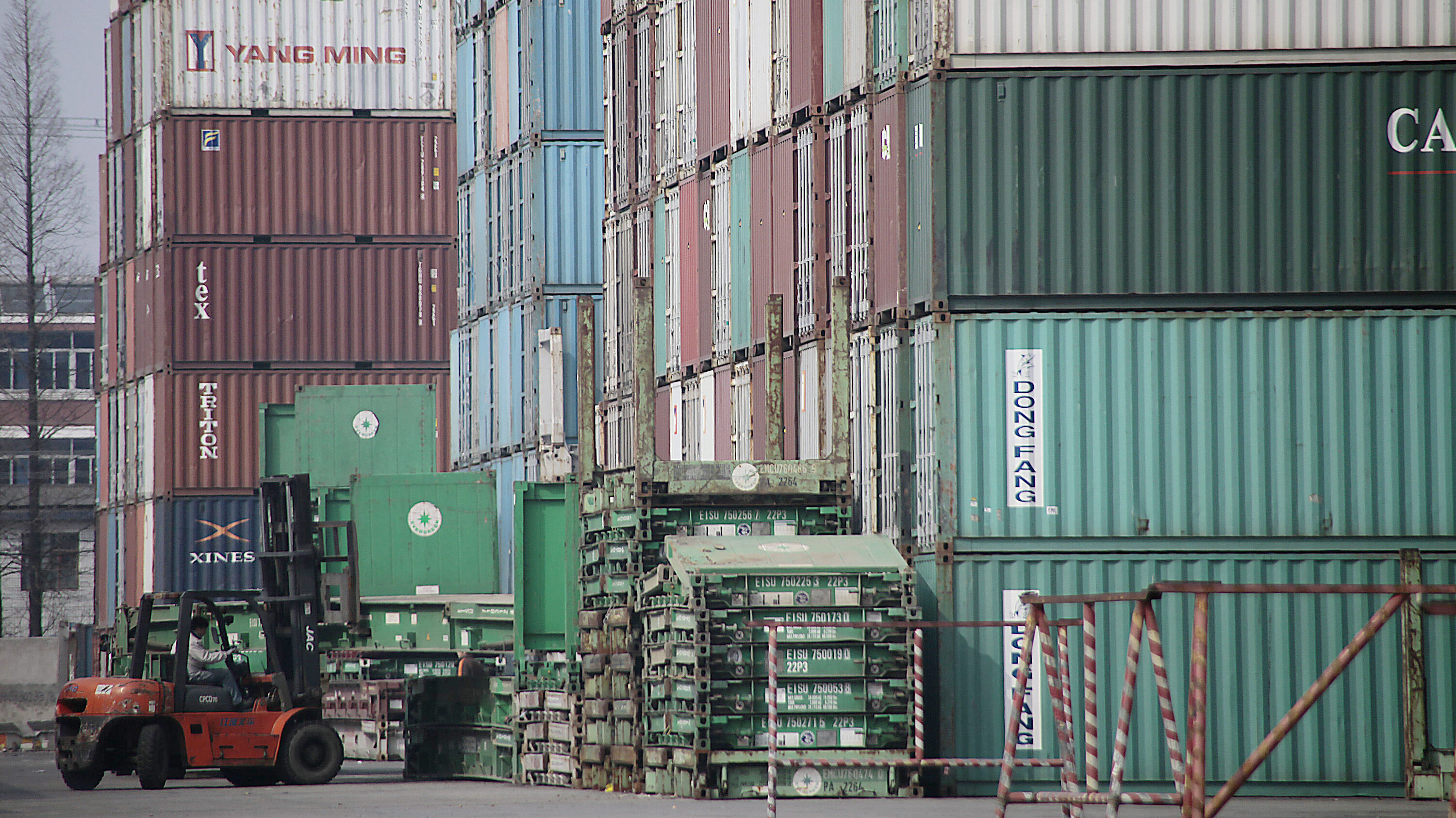 A forklift arranges the shipping containers near a port in Shangha