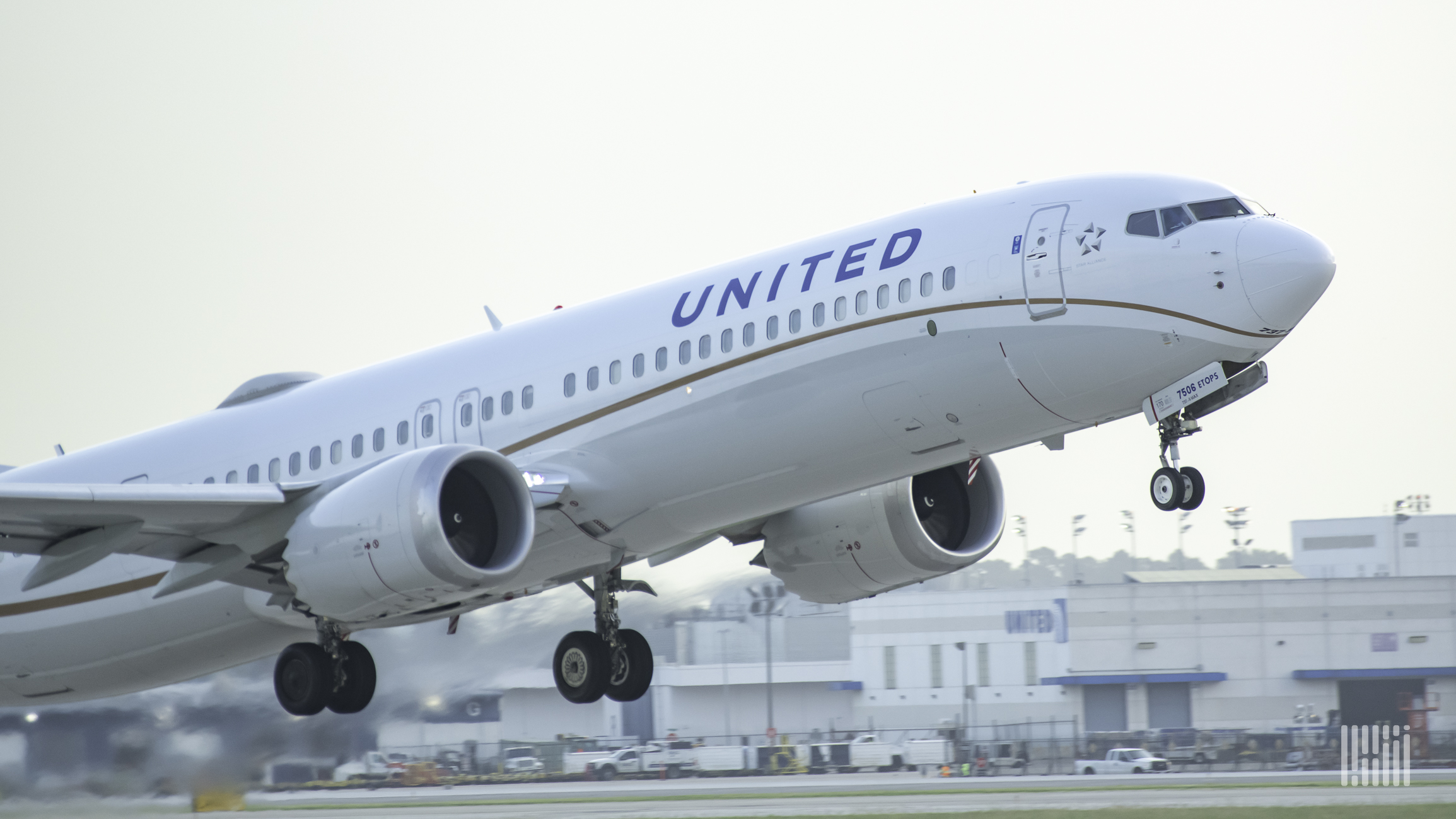 A close up of a white United Airlines jet taking off.