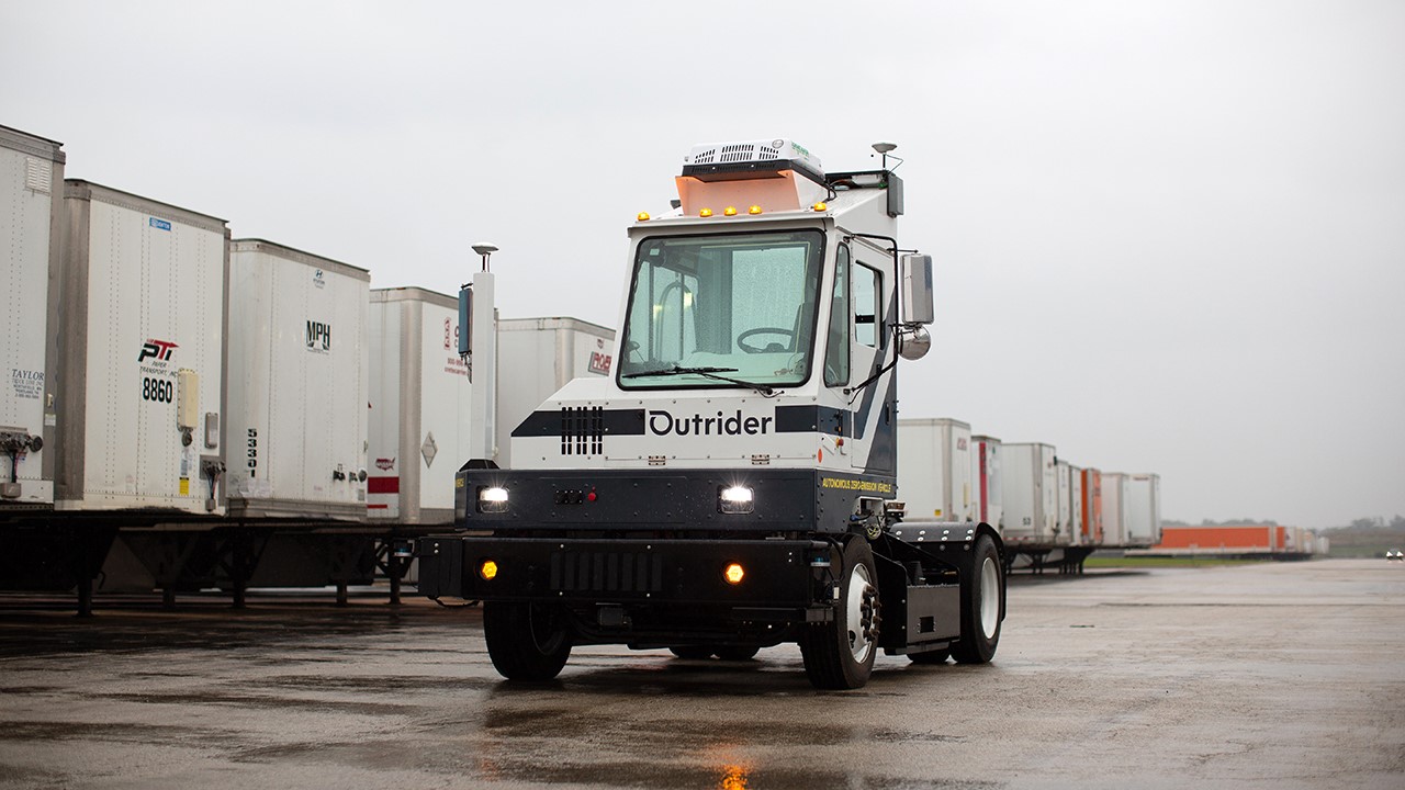 Outrider autonomous yard tractor next to a line of trailers