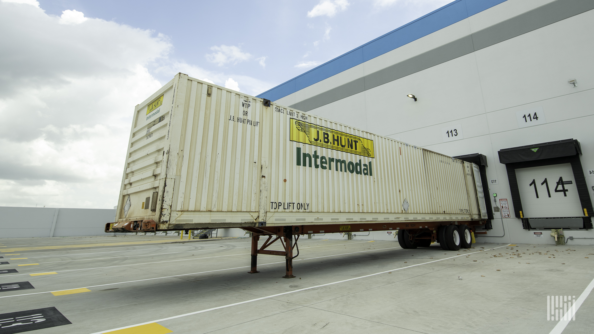 A J.B. Hunt intermodal trailer backed up to a warehouse door