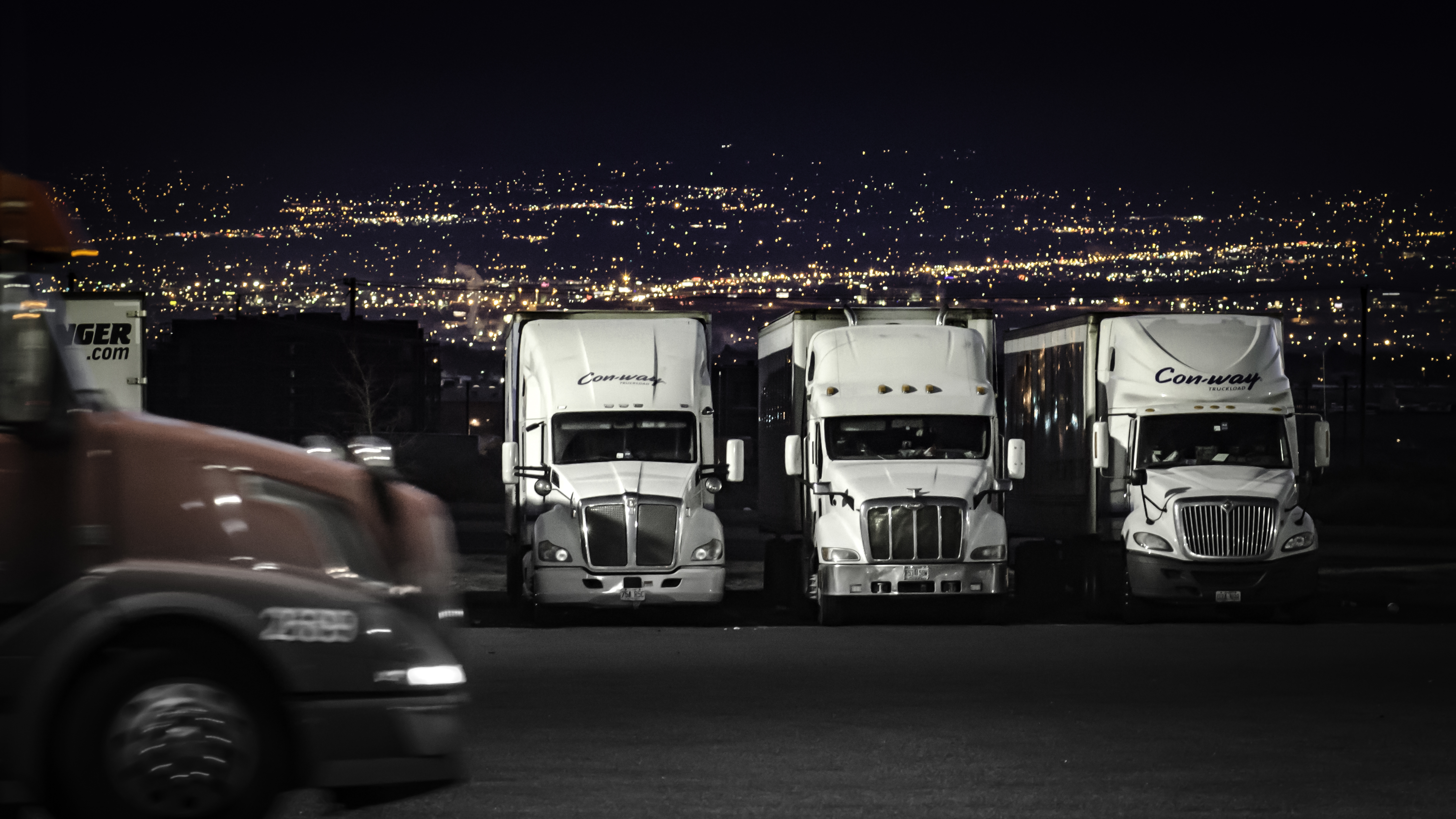 Trucks parked in parking lot at night.