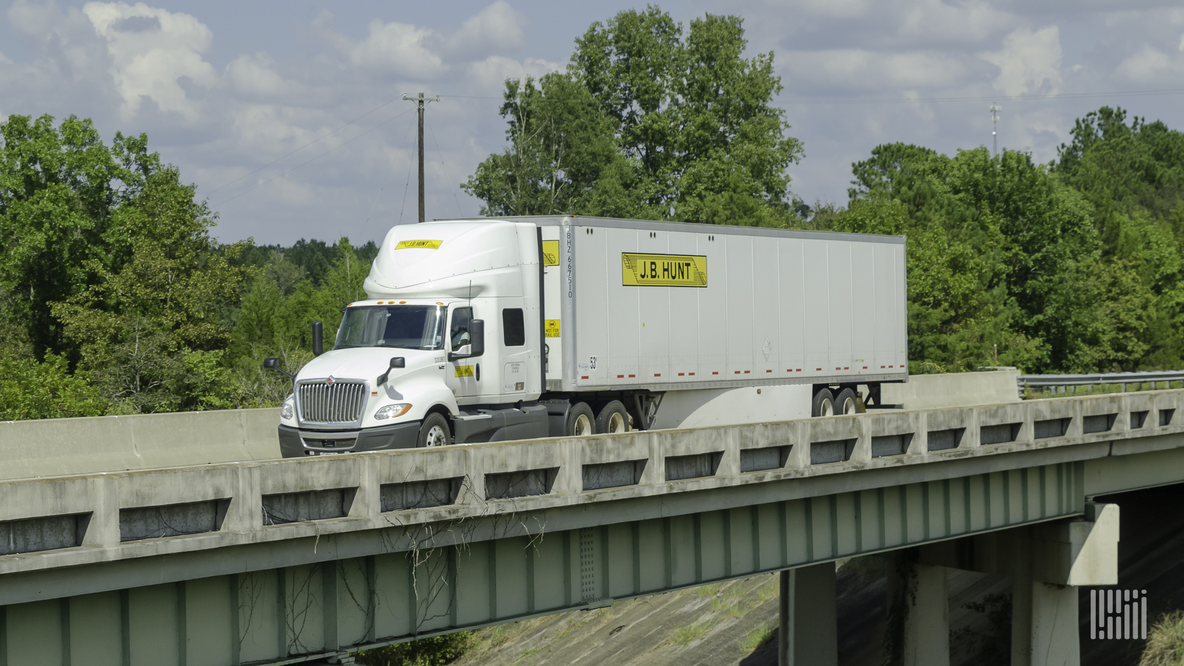 A J.B. Hunt tractor and trailer crossing a bridge