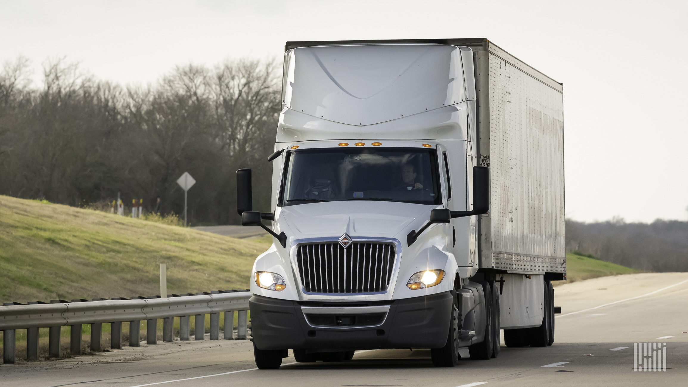 A white truck and trailer on highway