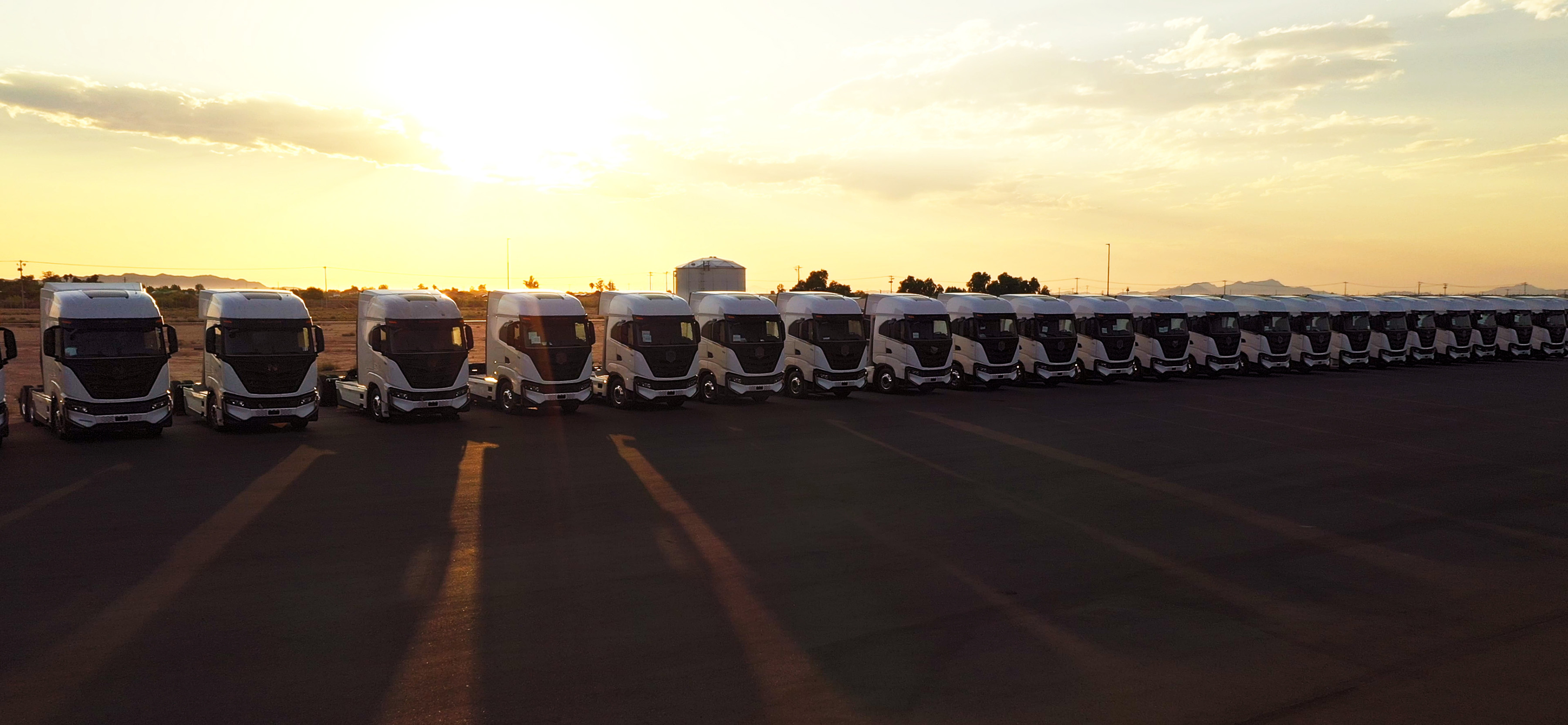 Row of Nikola Tre battery-electric trucks in shadow