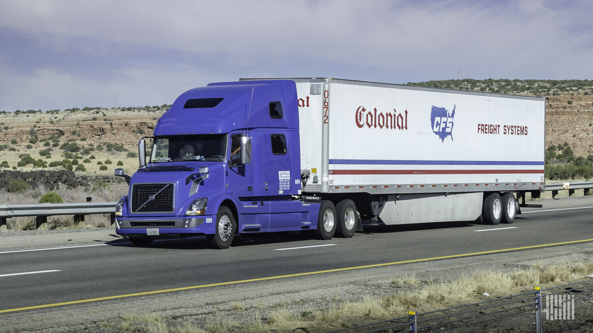 A blue tractor pulls a Colonial Freight Systems trailer