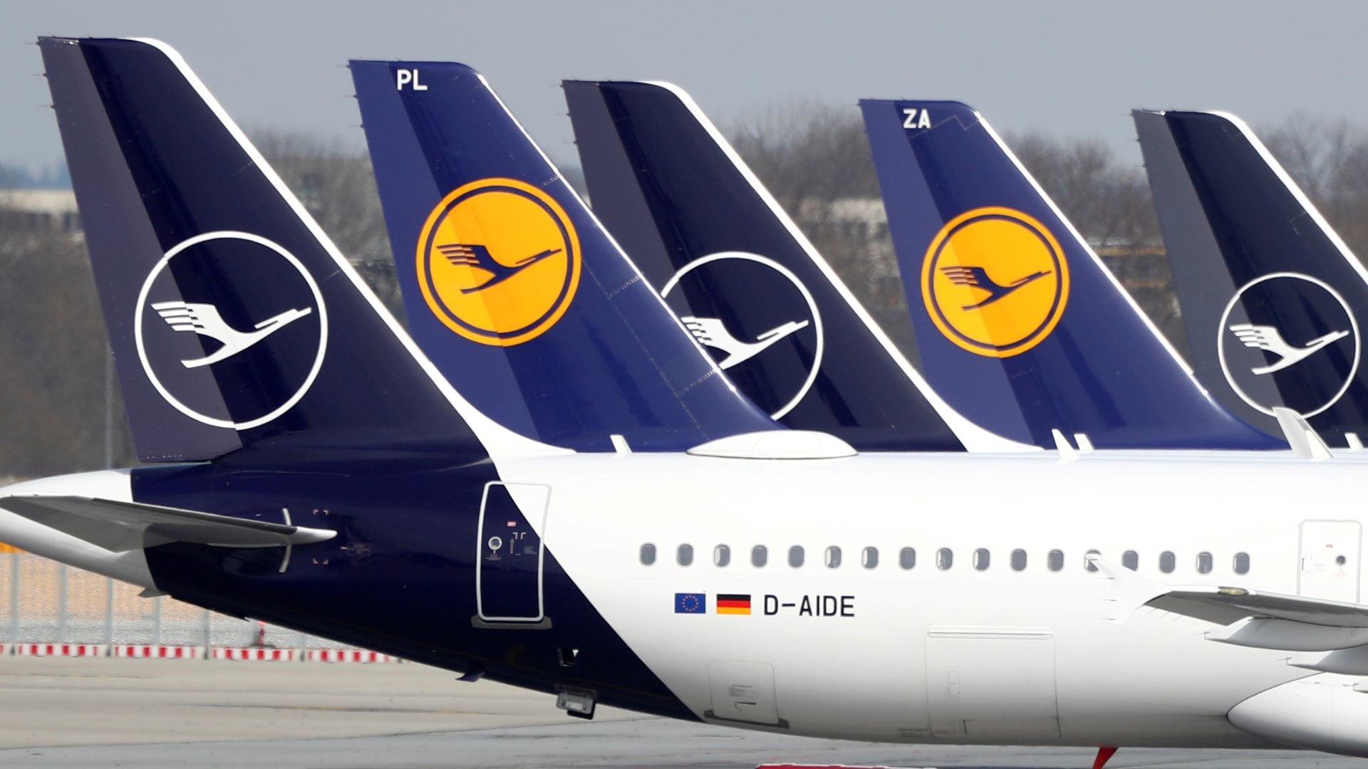 A line of Lufthansa aircraft, close up of blue tails.