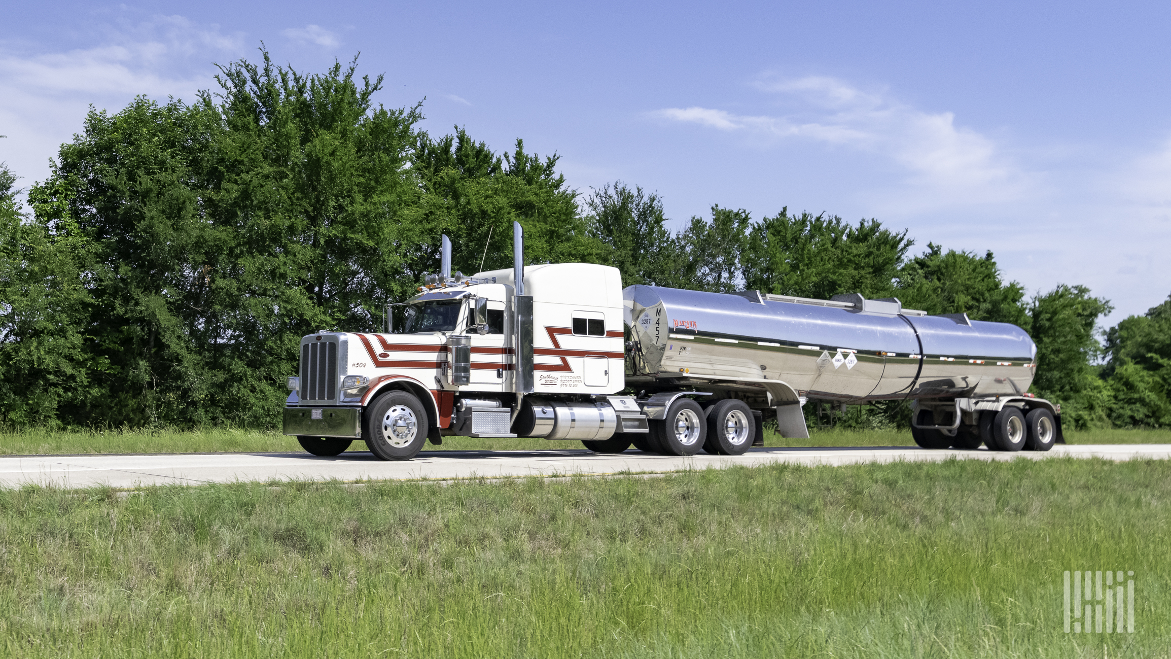 A truck hauling a tank trailer on the highway