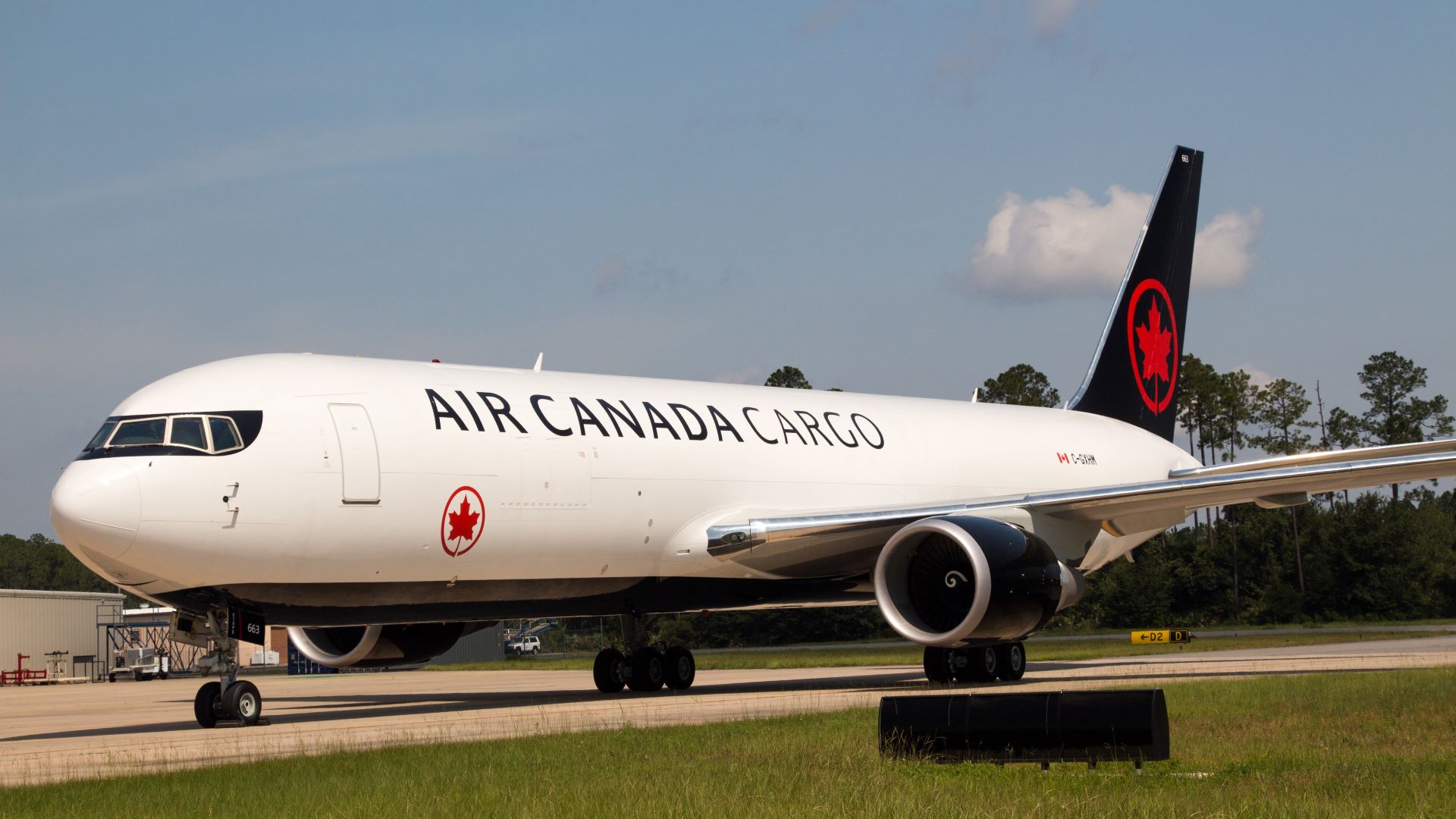 A white Air Canada Cargo jet with black and red accents on the tarmac.