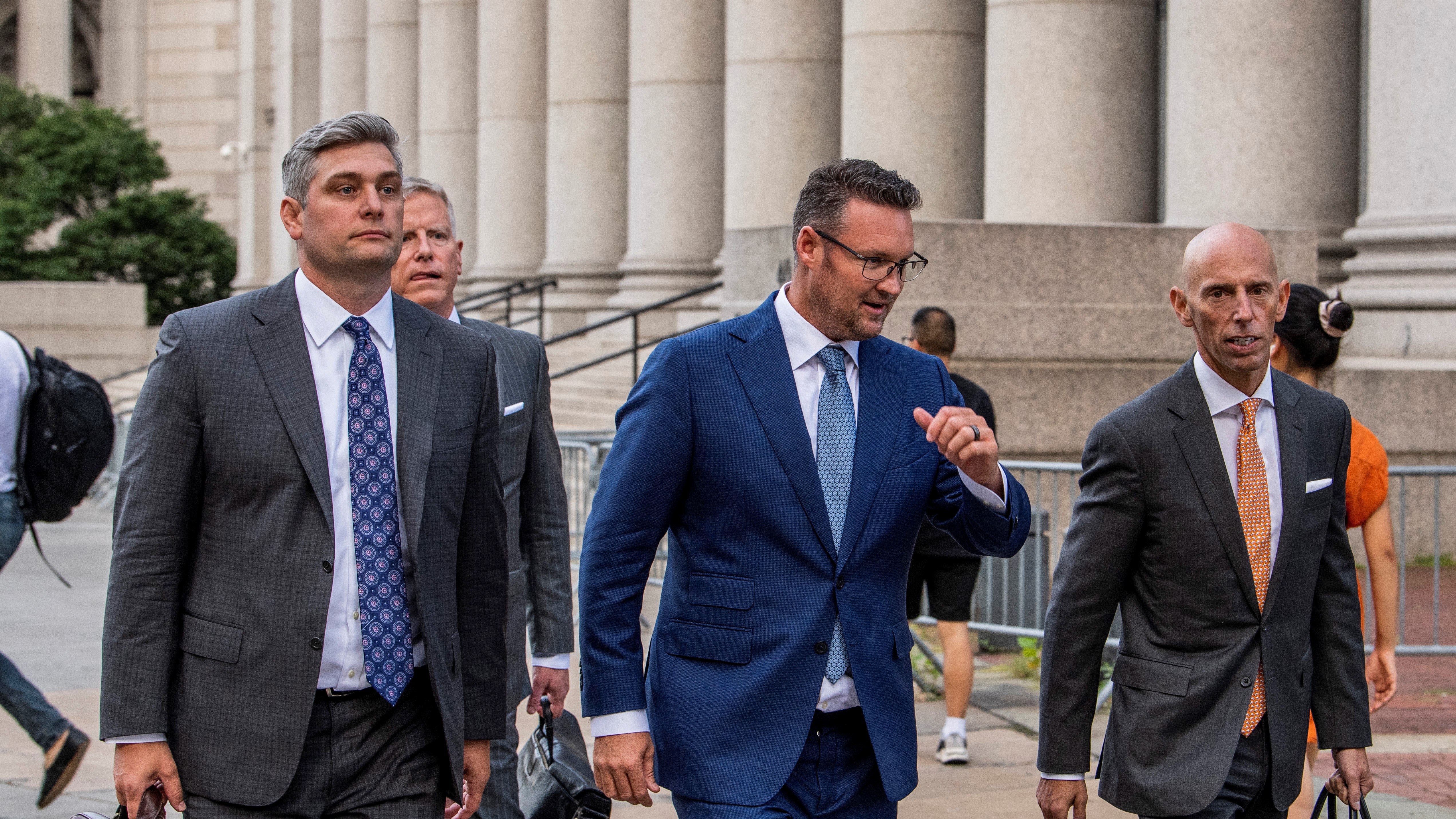 Lawyers and Trevor Milton walk to court