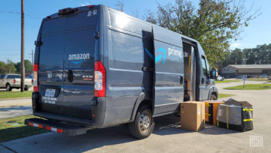 Amazon van with boxes sitting next to open door on street