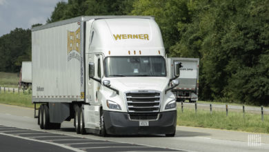 A white Werner tractor-trailer on the highway