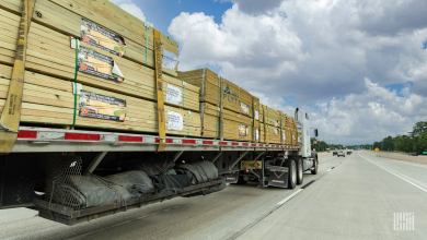 A flatbed rig moving lumber on the highway