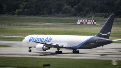 Rear side view of a white Amazon jet with blue tail ready to take off.