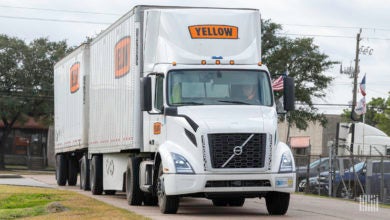 A Yellow tractor pulling two Yellow trailers at a terminal in Houston