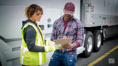 Woman holding clipboard for man to sign