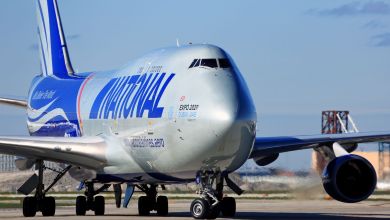 A silver-and-blue National Airlines jumbo jet. Close up front view.